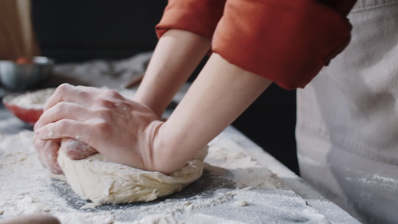 Mani di fornaia che prepara l'impasto