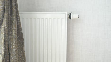 white radiator with thermostat in a room