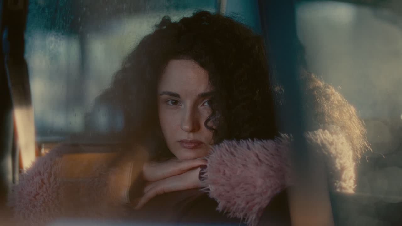Portrait of Beautiful Girl Sitting in Car, Looking Pensively into Camera