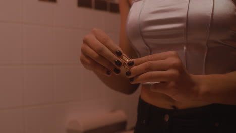 close up of an unrecognizable woman opening a lipstick in a bar bathroom