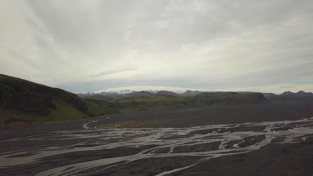 camiones aéreos de fiordos, arroyos y tierras altas verdes, glaciar breiðamerkurjökull en segundo plano en un día nublado, parque nacional vatnajökull, islandia