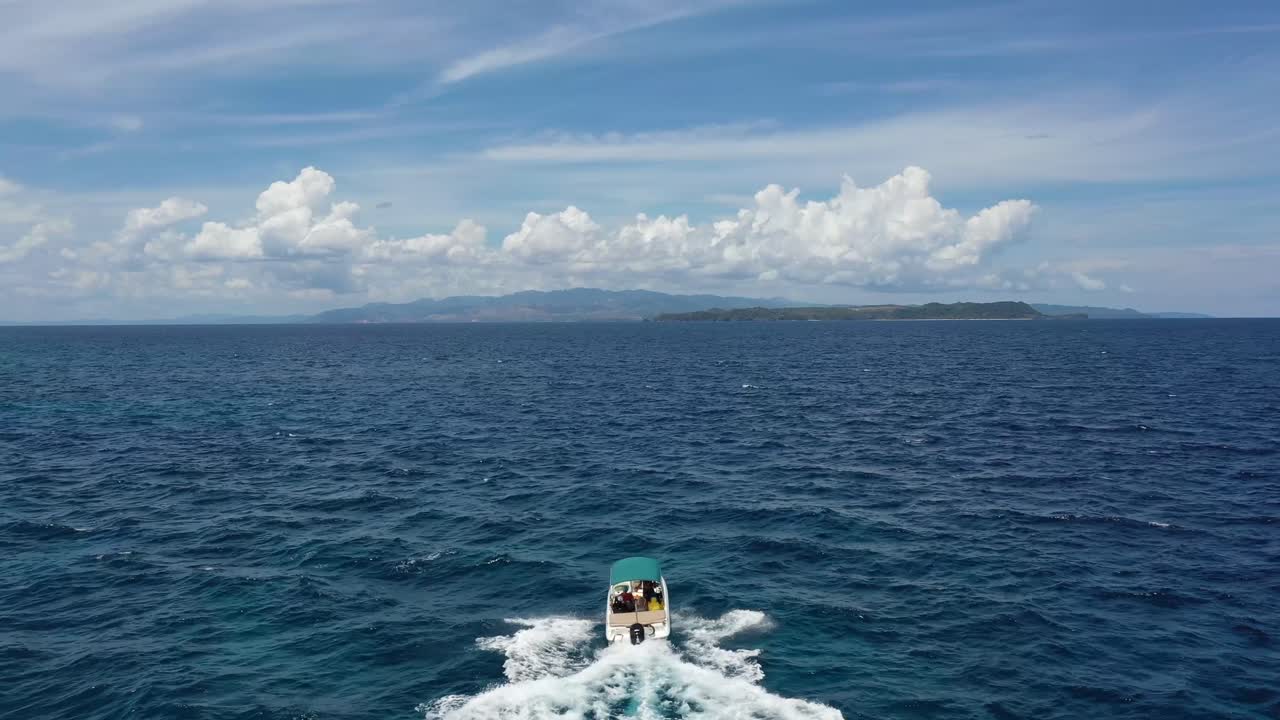 lancha blanca navegando en una superficie turquesa clara del mar hacia una isla
