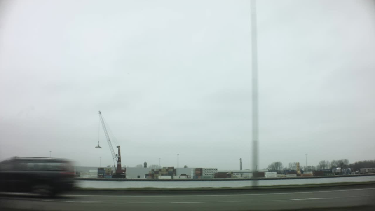 car ridding view of forest trees bus station grass land harbor steel factory city landscape sea water ocean passing