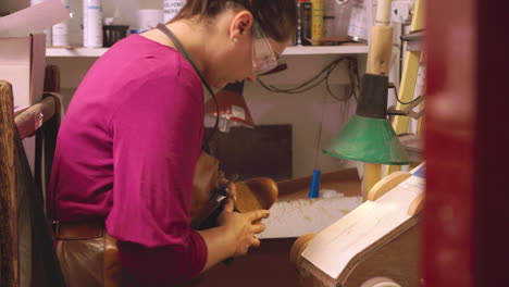 bespoke shoemaker smoothing leather whilst making shoe