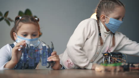 Little-Girls-With-Face-Mask-Building-Robots