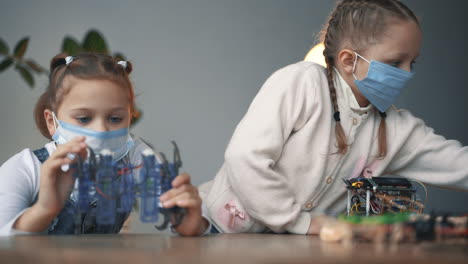 little girls with face mask building robots