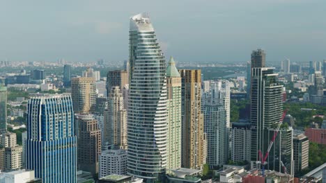 4k urban landscape shot of a panoramic view of buildings and skyscrapers in downtown bangkok, thailand during sunset from a rooftop