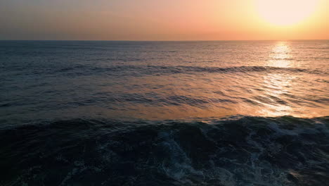 agua marina ondulante puesta de sol vista aérea. cielo dorado del amanecer sobre la superficie del mar tormentosa