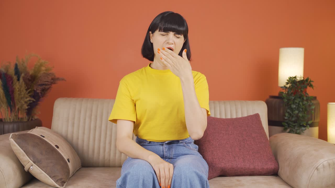 Sleepy woman yawns.