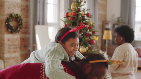 niña afroamericana divirtiéndose con su padre el día de navidad en casa