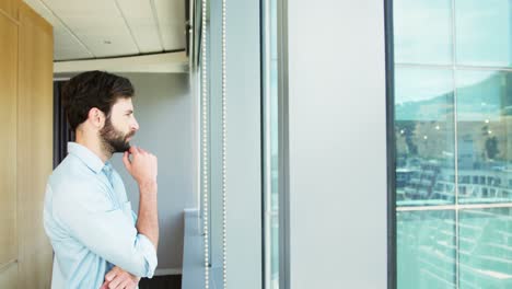 ejecutivo de negocios pensativo de pie cerca de la ventana