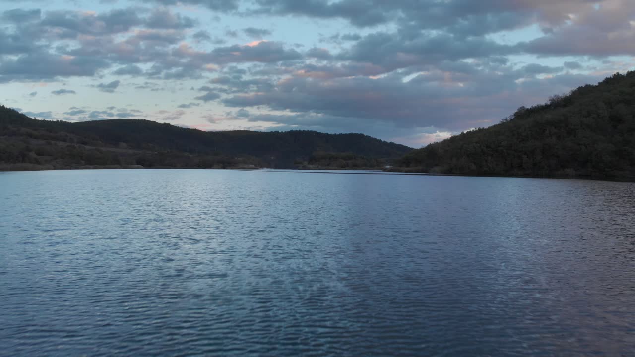 rápido aéreo sobre la montaña lago crepúsculo puesta de sol colores nubes púrpuras