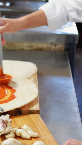 chef aplicando salsa en el pan plano