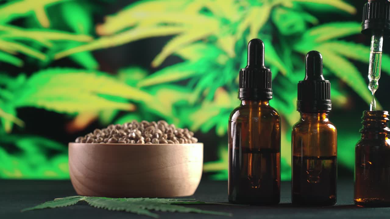 una pipeta de presión de mano de aceite de cbd cae en una botella de aceite de cannabis legalizado.
