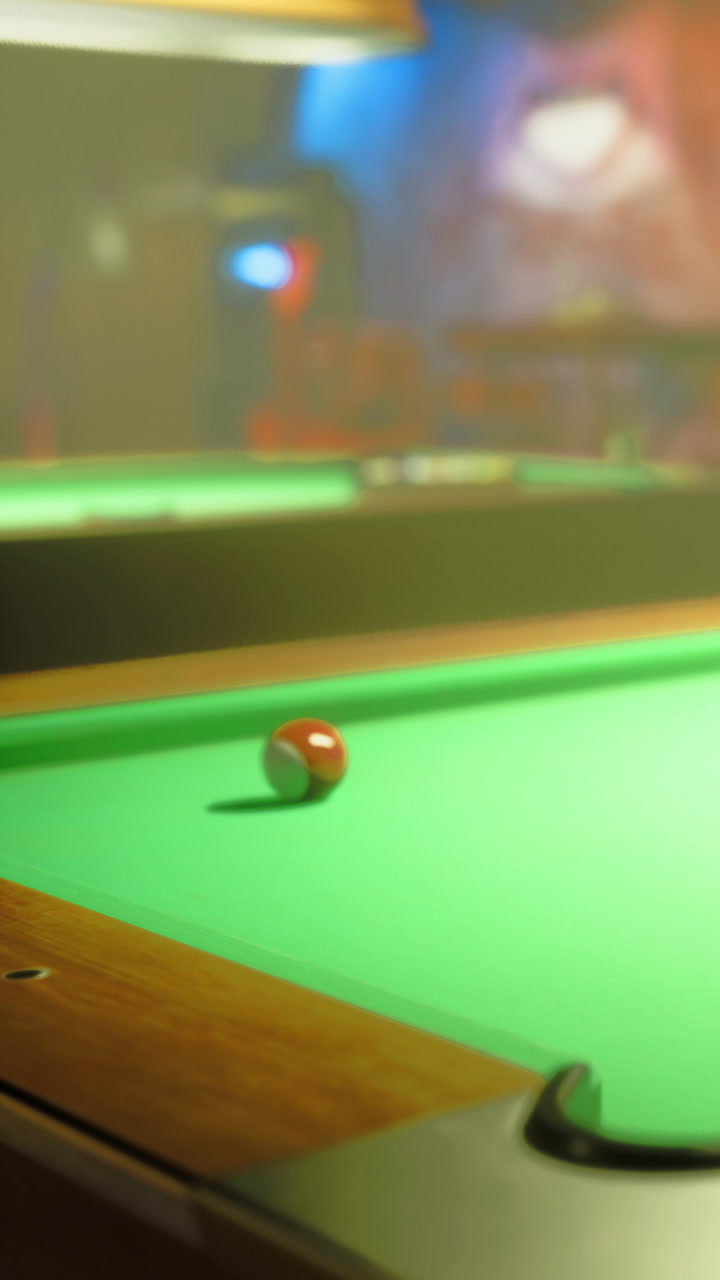 Pool table features a red ball in motion during a game at a local bar