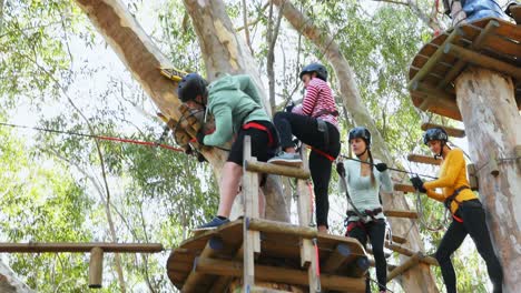 Man-assisting-women-to-fix-harness-on-zip-line-4K-4k