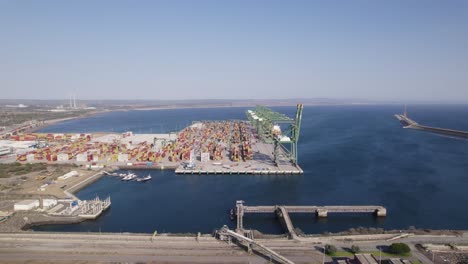 sines port, cargo terminal packed with colorful containers, aerial orbiting shot