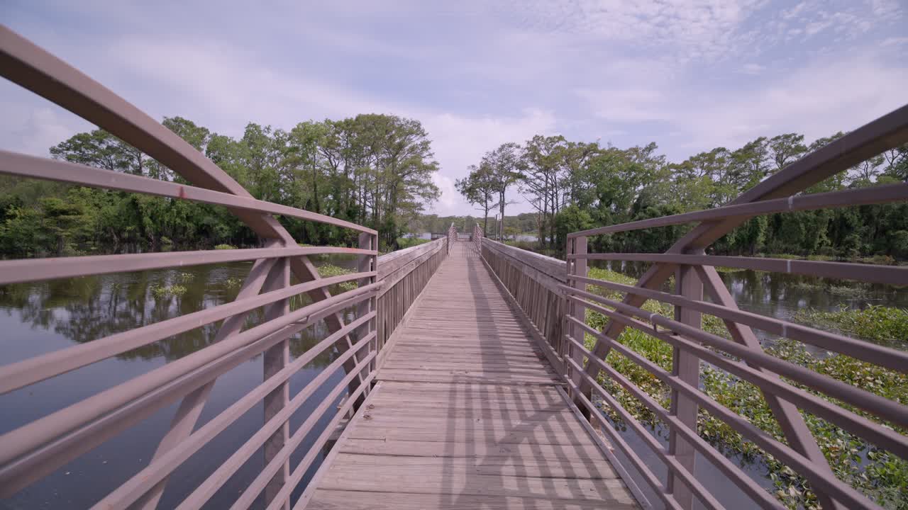 Long empty boardwalk of a swampy lake