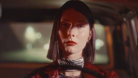 portrait of young attractive woman driving car at night