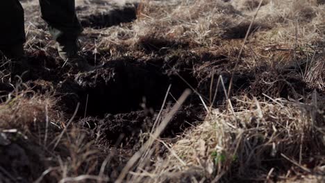 digging soil on farm field with shovel