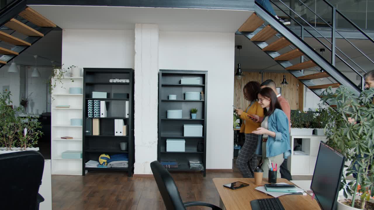 grupo de personas que vienen a la oficina de espacio abierto sentados en escritorios trabajando con computadoras