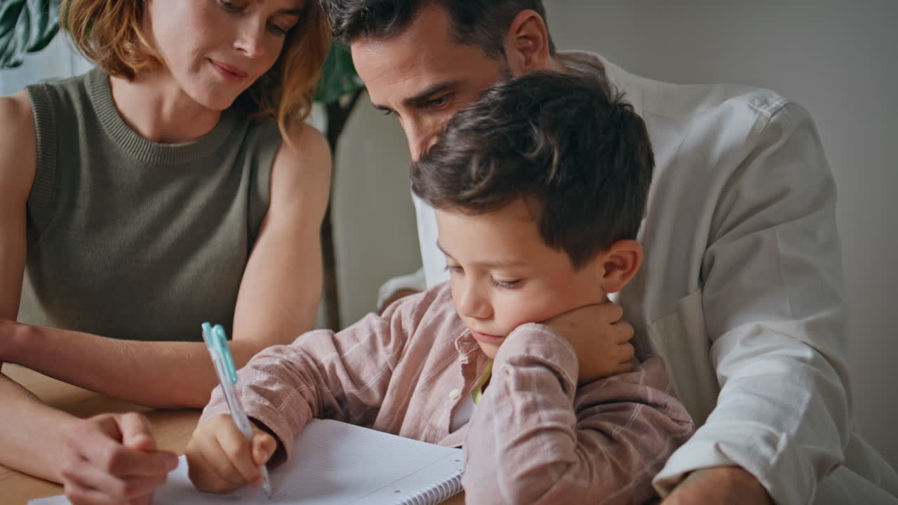 Parents helping son studying at home closeup. Little schoolboy doing homework