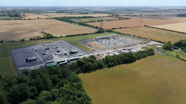Aerial drone footage of electrical substation with transformers and powerlines in Biggleswade England