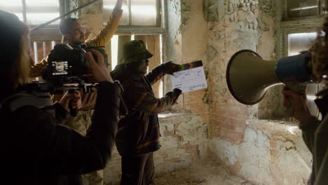 production team and cameraman recording the scene of a girl crashing into the wall in a ruined building