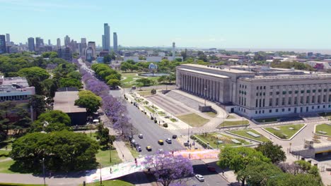 Traffic-On-The-Thoroughfare-In-Buenos-Aires,-Argentina-Passing-By-The-University-Of-Buenos-Aires-Faculty-Of-Law