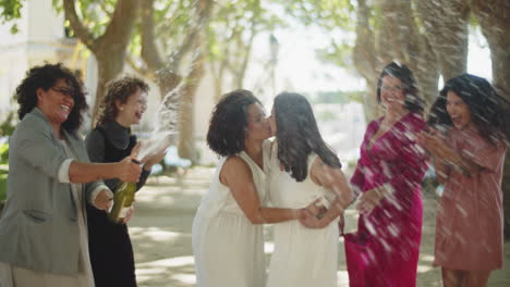 bridesmaid opening bottle of champagne at lesbian wedding