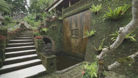 slow motion gimbal moves through lush jungle villa with balinese fountain dripping
