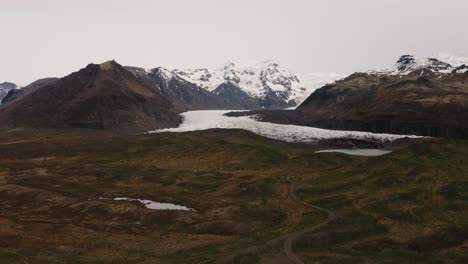 Drohnenaufnahmen-Aus-Der-Luft-Vom-Gletscher-In-Island-Mit-Bergen,-Schnee-Und-Felsen