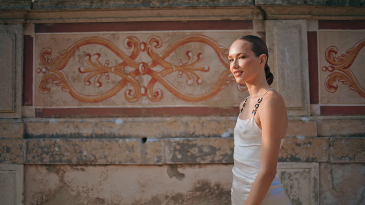 una mujer sonriente caminando por un lugar histórico disfrutando de unas vacaciones despreocupadas de cerca.