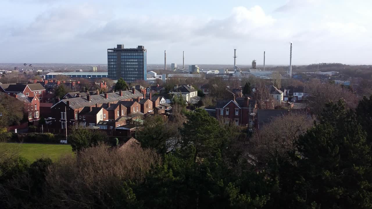 vista aérea sobre los árboles del parque con pájaros volando a través de la escena al paisaje de la ciudad industrial con rascacielos azules, merseyside, inglaterra
