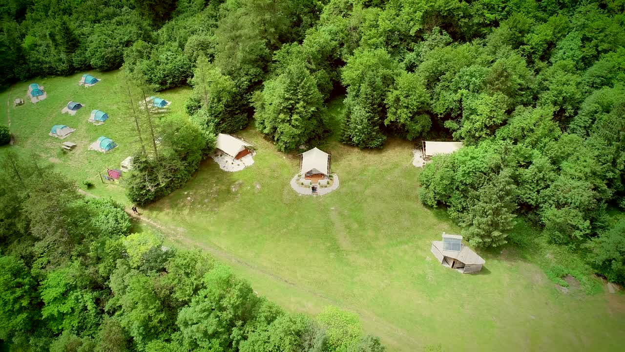vista aérea de una pareja de pie frente a una zona de descanso en un campamento.