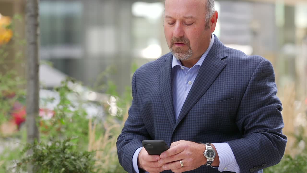 Mand kigger væk, læser derefter en sms og kigger så bekymret omkring sig