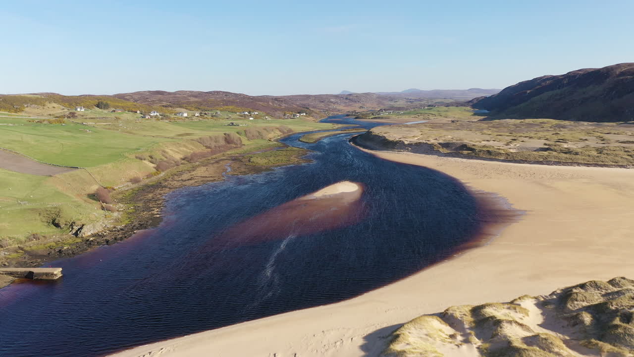 Aerial shot flying up a river estuary in Scotland on a stunning summer's day