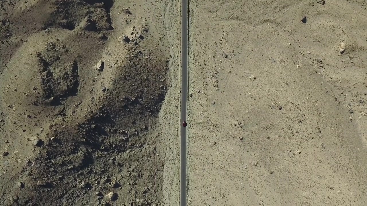 Auto in viaggio su un'autostrada nel paesaggio arido della valle di Skardu in Pakistan. Ripresa aerea in movimento