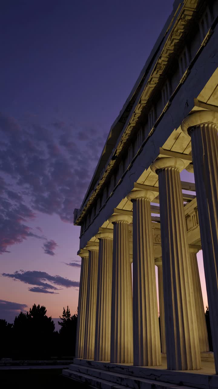 A dramatic low-angle video shot of an ancient Greek temple at dusk, highlighting its illuminated