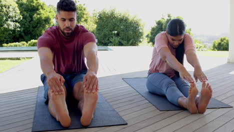 couple practicing yoga stretches on deck, focusing on flexibility and relaxation