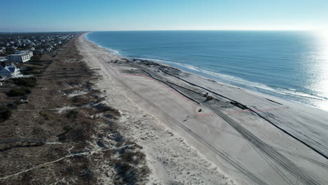 aerial shot of beach nourishment, or adding sand or sediment to beaches to combat erosion, can have negative impacts on wildlife and ecosystems, with water coming out of pipe