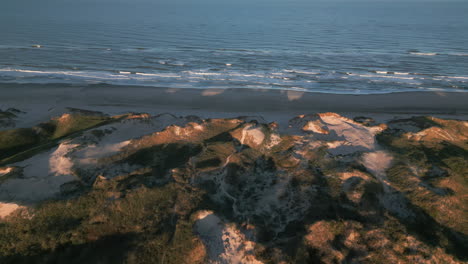 morning light on the dunes with gentle waves at danish beach