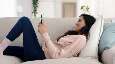 relaxing at home, indian woman using smartphone on cozy sofa