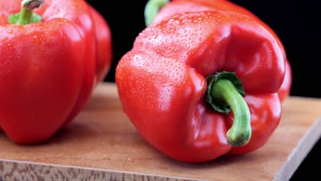 Pimientos-Rojos-Frescos-Sobre-Tabla-De-Cortar-De-Madera,-Sartén-De-Primer-Plano