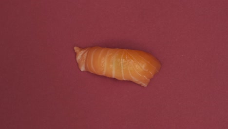 un rollo de sushi girando sobre un fondo rojo