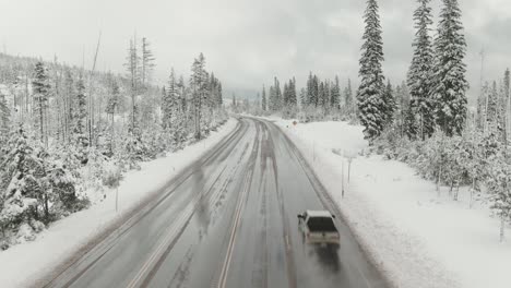 carretera rural aérea de 4k en la nieve con carro de drones de tráfico fuera de tiro