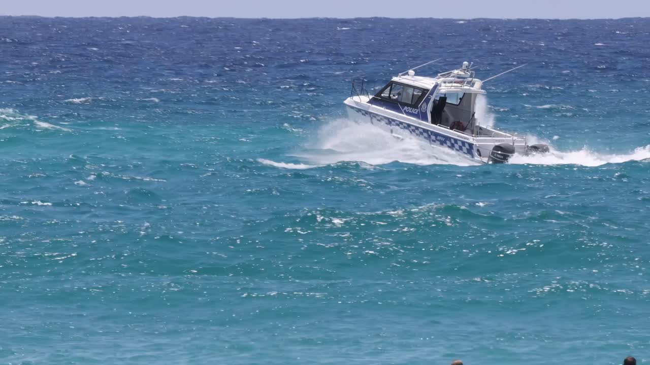 A speedboat cuts through the vibrant turquoise ocean, creating dynamic splashes and waves under a clear sky.