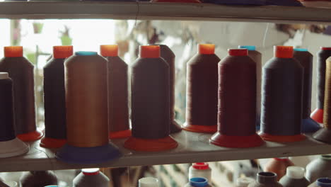 Spools-of-Thread-on-Shelves-in-Workshop