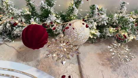 snowy christmas decorations with red and gold ornaments and glittering snowflakes on festive garland