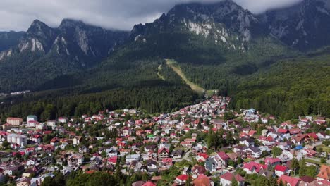 vibrant town facing surreal carpathian mountain in transylvania, romania